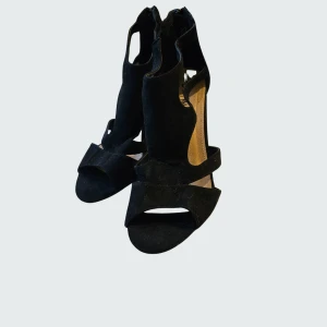 Svart festsandalett från Duffy - Elegant festsandalett i svart microfiber med bred klack och öppen tå från Duffy. Skorna har utskurna detaljer på sidorna och dragkedja bak för enkel påtagning. Använd någon enstaka gång så i fint skick. Inköpta för 449 SEK. Rökfritt, men katt finns i hemmet.              