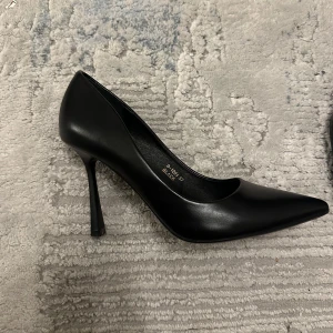 Svarta pumps  - Snygga svarta pumps från Ideal Shoes men köpt från bohoo med spetsig tå och hög klack. Skorna är tillverkade i slätt syntetmaterial Perfekta för dig som gillar klassisk och elegant stil med en edge. 