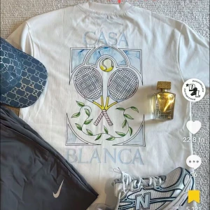 Casablanca t-shirt med grafiskt tryck - Casablanca t-shirt i bomull med coolt grafiskt tryck på ryggen och bröstet. Finns i vitt och svart, med motiv som tennisracketar, färgglada rutor eller en solnedgång i fönsterdesign. Rund hals och korta ärmar, perfekt för dig som gillar sportig och trendig stil.