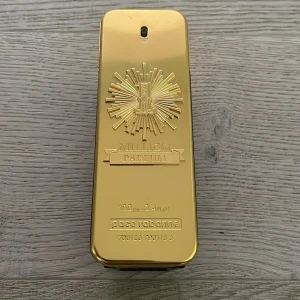 Paco Rabanne 1 Million Parfum 100ml - Säljer en lyxig 1 Million Parfum från Paco Rabanne med cirka 70ml kvar. Flaskan är rektangulär med en glansig guldfärgad framsida och detaljer i relief, samt mörktonad baksida. Parfymen har en ikonisk och exklusiv design som verkligen sticker ut i badrumshyllan.