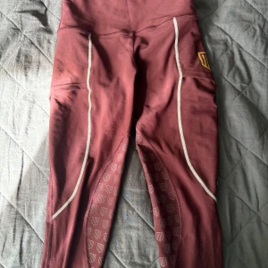 Vinröda leggings från Maya Delorez - Vinröda ridtights från Maya Delorez med fickor på sidorna och deras logga på benet.  Använda ganska mycket och liten fläck och lite nopprigt längst ner på benet men ingenting som syns (särskilt inte med sina ridskor på 💕).  De har hög midja, storleken är xxs 💕 ursprungligt pris är 899 kr 💕
