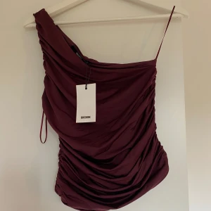 Vinröd oneshoulder klänning Bik Bok - Snygg vinröd topp från Bik Bok med draperad design och oneshoulder-modell. 