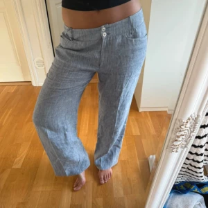 Ljusgrå raka linnebyxor  - Snygga ljusgrå linnebyxor med två knappar i midjan och raka, vida ben. Handgjorda och ingen täcken på användning