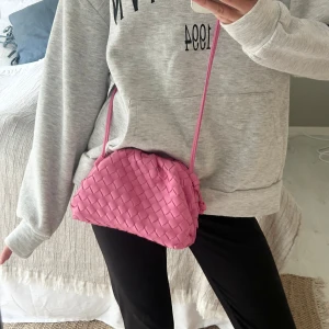 Flätad rosa väska - Säljer en superfin rosa väska med flätad design i jättebra skick. Köpt av en annan på Plick o vet ej märket (står inget i) men den är rejäl!💖
