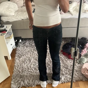 Mörkblå bootcut jeans LTB Valerie W27 L34 - Snygga mörkblå jeans från LTB, modell Valerie. De har låg midja och bootcut-ben, vilket ger en klassisk siluett. Jeansen är tillverkade i stretchig bomullsblandning för en bekväm passform. Perfekta för dig som gillar en tidlös look med lite extra edge.