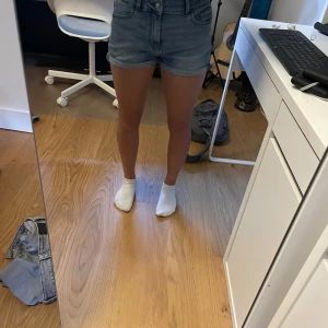 Jeansshorts från Scotch & Soda - Snygga jeansshorts från Scotch & Soda. Klassisk blå denim med bälteshällor och knapp- samt dragkedjestängning. Det finns gummiband i midjan och går därför att justera storleken i midjan.