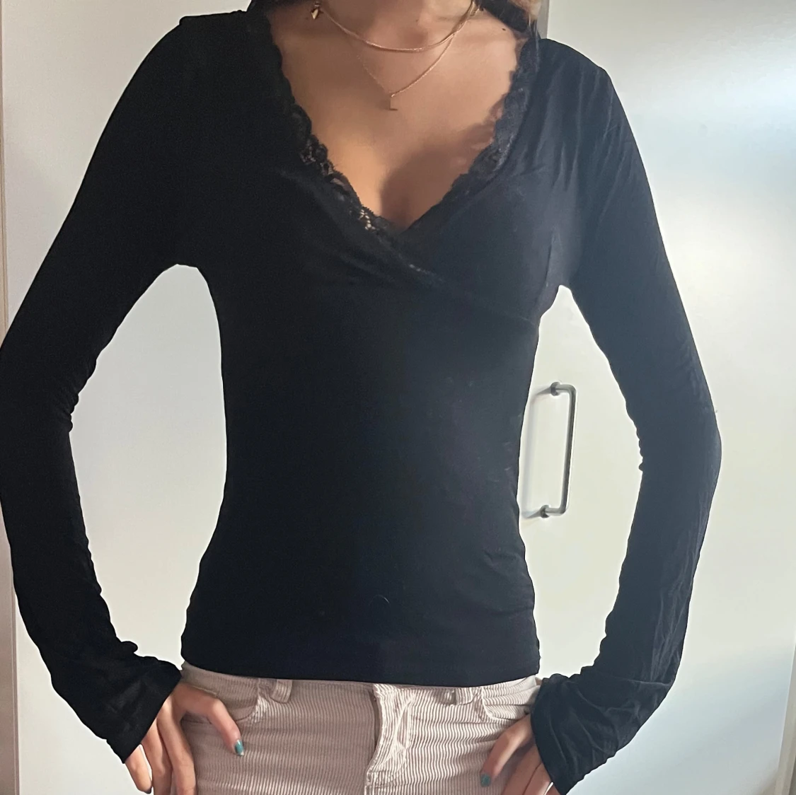 Svart omlottopp med spetsdetalj från Nelly