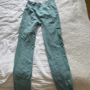 Turkosa träningstights från Lindex - Oanvända turkosa träningstights från Lindex med hög midja och mörkgröna detaljer längs sidorna. Stretchigt material som sitter tight.