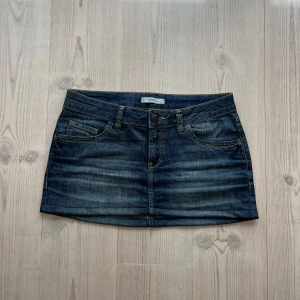 Blå lågmidjad jeanskjol  - Blå jeanskjol från Esprit i fint skick. Kan inte hitta storlek men skulle säga M, passar även S. Tvärs över midjan är det 42 cm och den är ca 31 cm lång (längs med sidan). Fint skick. Använd gärna köp nu!