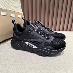 Dior B22 - Snygga chunky sneakers från Dior i svart med mesh och skinnpaneler. Skorna har reflekterande detaljer i lila och silver, samt kraftig sula och snörning. Perfekta för dig som gillar statement-sneakers med modern vibe. Har regnbåge reflex, priset är ej hugget i sten och kan förhandlas vid snabb affär: ) kommer med original nog ( boxen har en liten skada )