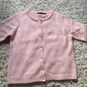 Ljusrosa kofta med pärlknappar XS - Supersöt ljusrosa kofta från Lager i mjukt stickat material. Helt ny och oanvänd! Bra material nyskick!