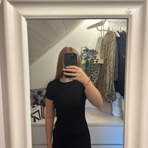 Svart tight kortklänning - Säljer en svart, tight och enkel kortklänning med rund halsringning och korta ärmar. Säljer den då den är för liten. Använd endast en gång 