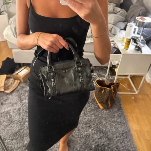 Svart handväska från Zadig & Voltaire - Cool svart handväska i skinn från Zadig & Voltaire med silverfärgade metalldetaljer och dragkedjor framtill. Väskan har både handtag och avtagbar axelrem, väldigt sparsamt använd så mycket bra skick! Ny pris runt 6000kr, skriv för fler bilder finns lite defekt vid spännerna men inget som syns mycket!