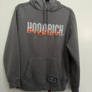 LIMITED Hoodrich XS Grå hoodie  - Snygg grå hoodie från Hoodrich i storlek XS. Den här tröjan är en limited edition och går inte längre att köpa i affärer. Svår att få tag på! Perfekt för dig som vill ha något unikt som inte alla andra har. Tröjan har huva med snörning, magficka och tryck även på ryggen. Perfekt för dig som gillar streetwear och vill sticka ut med coola detaljer. Ett problem med den är att ena snöret har tappat sin plastbit men det ändrar inte mycket på hoodien.