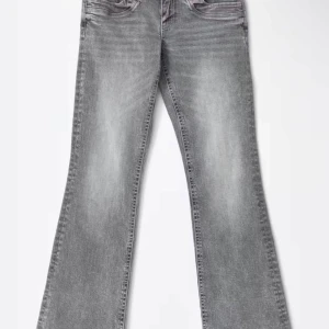 Grå bootcut jeans med tvättad look - Säljer ett par grå bootcut jeans som är low waist med snyggt tvättad finish. Jeansen har klassisk femficksdesign, normal passform och är tillverkade i mjukt denimtyg. Perfekta för dig som gillar en retro vibe och vill ha ett par jeans som sticker ut lite extra. (Kan skicka fler bilder om det behövs🫶)