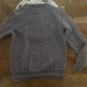 Grå stickad tröja från J.Lindeberg -  Snygg grå stickad tröja från J.Lindeberg i storlek Xs (står M men är krypmt i tvätten) Väldigt bra skick