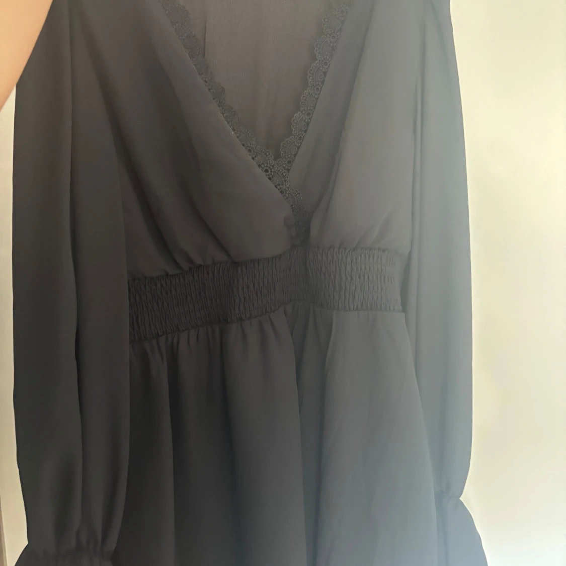 Svart omlottklänning med spetsdetalj