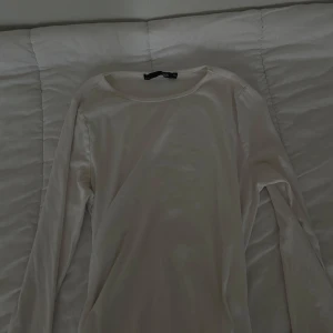 Vit långärmad tröja från 157 - En basic vit långärmad tröja från 157 i storlek XL. Tröjan har rund halsringning och är gjord i mjuk bomull, perfekt för lager-på-lager eller chill dagar. Enkel och clean design som funkar till det mesta. Den är lite för stor men så skönt material