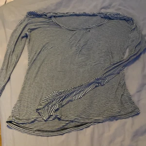 Randig långärmad tröja i bomull - Säljer en tunn långärmad tröja med svartvita ränder. Tröjan har en rundad halsringning och är gjord i mjuk bomull, perfekt för lager-på-lager. Passformen är normal och materialet känns riktigt skönt mot huden. OBS ett hål vid nyckelbenen