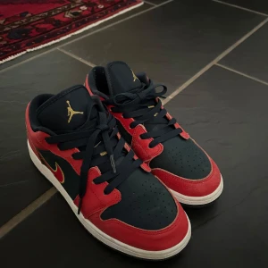 Nike Air Jordan 1 Low röd/marinblå - Snygga Nike Air Jordan 1 Low sneakers i marinblått och rött med gulddetaljer. Använd ett fåtal gånger. 