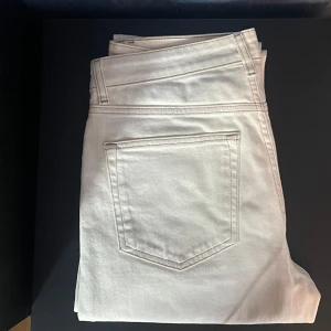 Vita  jeans  - Snygga vita jeans med klassisk femficksdesign och raka ben. Jeansen har hög midja och är tillverkade i bomull för en skön och stilren look. Perfekta att matcha med allt och ger en fräsch vibe till outfiten. 