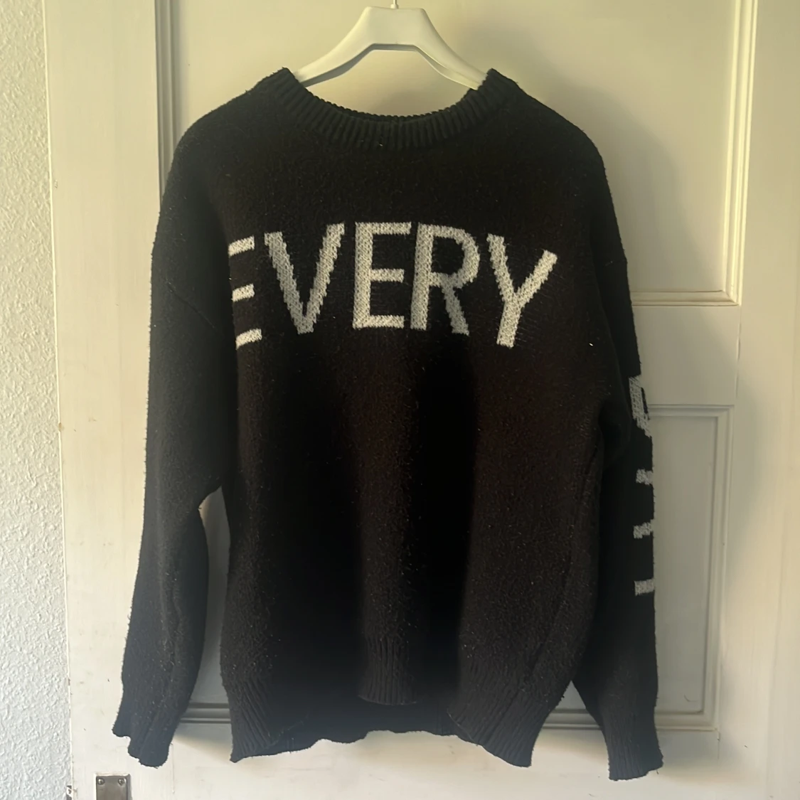 Svart stickad tröja med text