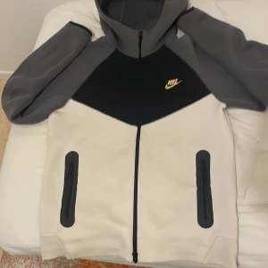 Nike Tech Fleece hoodie jacka S - Nike Tech Fleece hoodie i svart, grått och vit. Koftan har hel dragkedja,  Perfekt för dig som gillar sportig och clean stil. Jätte skönt material