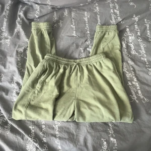 Mintgröna mjukisbyxor med snörning - Säljer ett par mintgröna mjukisbyxor med elastisk midja och snörning. Byxorna har raka ben, muddar vid bensluten och två sidofickor. Perfekta för chill dagar eller när du vill vara extra bekväm.