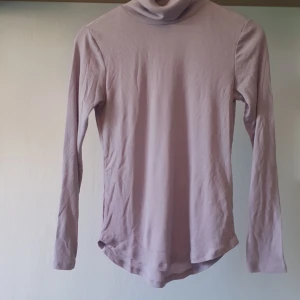 Ljuslila ribbad polotröja  - Superfin ljuslila polotröja från H&M i ribbad bomull. Tröjan har lång ärm och en klassisk polokrage som ger en chill vibe. Perfekt att styla med jeans eller kjol för en snygg look. Mjuk och skön mot huden. Lite nopprig men det kan fixas med en noppborttagare