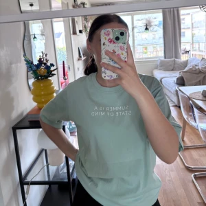 Mintgrön t-shirt från 157 med tryck - Fräsch mintgrön t-shirt från 157 i 100% bomull. Oversized fit med korta ärmar och vit text på bröstet: 'SUMMER IS A STATE OF MIND'. Perfekt för dig som gillar chill och enkel stil.