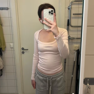 Långärmad ljusrosa topp från Gina Tricot - Säljer en ljusrosa långärmad topp med rund, djup ringning. Materialet är ribbat och stretchigt. Storlek XS men passar även S. Knappt använd då det är fel storlek för mig. Köptes för 199kr. Finns även i vit, båda tröjorna för 110kr eller en för 70kr!