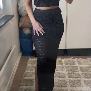 Svart stickad långkjol med slits - Detta är ett fantastiskt tvådelat vitt sommar set, med slits. Perfekt till vardags och fest! Kjolen är i storlek 36 men passar även 32,34 och 38 då matrealet är strechigt. Toppen är i storlek 38 men passar även 34 och 36. Mina vanliga mått brukar ligga mellan 34,36, har du samma storlek, lite mindre/större så passar detta sett perfekt! Skönt, snyggt och mysigt. Har även ett exakt likadant set i vit till försäljning.