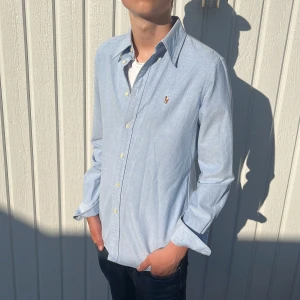 Ljusblå Ralph Lauren Skjorta - Tja! Säljer nu denna galet feta Ralph Lauren Skjortan! Toppskick utan några defekter, 9/10! Färgen är Ljusblå, riktigt fet nu till sommaren!☀️Storlek M Custom Fit, Fits=S/M. Äkta med supplier number, 100% bomull! Hör av dig vid minsta fråga eller fundering!🌟