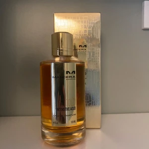 Mancera Gold Intensive Aoud EdP 120ml - Lyxig parfym från Mancera, Gold Intensive Aoud, 120 ml Eau de Parfum. Flaskan är cylindrisk med guldfärgad etikett och lock. Doften har träiga, rosiga och musky toner med inslag av citrus, varm krydda, puder och aromatiska noter.