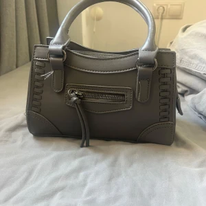 Grå väska  - Säljer denna super fina väskan som nästan aldrig är använd. Super fin till både skolan och fest🫶