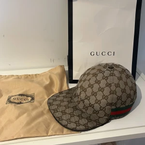 Gucci keps med GG-mönster och läderdetalj - Äkta keps från Gucci gamla modellen svårt att få tag i dessa kepsar med så bra utseende