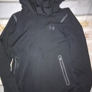 Under armour vindjacka helt svart  - Helt ny skick har inte ens använd om ni är intresserade finns också en mörkblå jacka men samma priset kan diskuteras 
