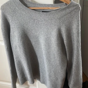 Grå stickad tröja från vero moda  - En enkel och stilren grå stickad tröja med rund halsringning och ribbade muddar. Perfekt för lager-på-lager och passar till både jeans och kjol. Långärmad och mjuk, ett måste i garderoben för kyligare dagar.