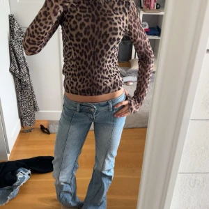 Leopardmönstrad långärmad tröja - Säljer en snygg långärmad tröja med leopardmönster i bruna och svarta toner. Tröjan har en tight passform och är perfekt för dig som vill sticka ut lite extra. Materialet känns mjukt och följsamt mot kroppen. Superfin att styla med jeans eller kjol!