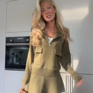 Olivgrön stickad tröja  med fickor - Supersnygg olivgrön stickad tröja med långa ärmar, två stora fickor framtill och ribbade detaljer vid midja och ärmslut. Halv dragkedja vid halsen ger en cool touch. Perfekt för dig som gillar en chill men trendig look.💚Strl Xl, men sitter som en L