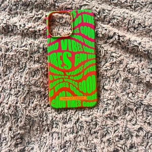 Färgglatt mobilskal från iDeal of Sweden - Säljer ett riktigt färgstarkt mobilskal från iDeal of Sweden med neongröna texter 'GOOD VIBES' på en orange och rosa bakgrund. Skalet har en cool, modern vibe och passar perfekt för dig som vill sticka ut. iPhone 13 Pro Max!!