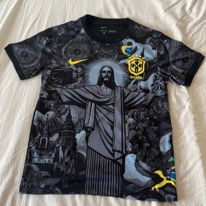 Grå Nike Brasilien fotbollströja - Storlek M. Snygg svart Brasilien fotbollströja från Nike. Jätte bra kvalite och bekväm. Helt oanvänd och ren. Brasilien som logga och Jesus i mitten. Inget namn på ryggen. Priset kan diskuteras