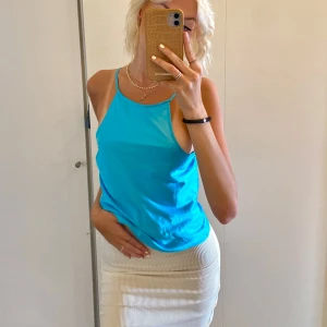 Blå topp  - Säljer denna fina turkosa silkestoppen från NA-KD. Tunna axelband med en snygg öppen rygg. Perfekt till sommaren! Använd 1 gång!🩵