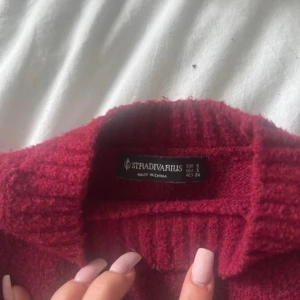 Vinröd stickad tröja Stradivarius - Mysig vinröd stickad tröja från Stradivarius i storlek S. Tröjan har en klassisk rund halsringning, ribbade muddar och är långärmad. Köpt i Grekland och inte använd mycket, lite noppig men inga andra tecken. Den är kort som en magtröja