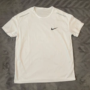 Nike Träningströja - En bekväm och luftig träningströja från Nike i storlek s. Tröjan sitter löst vid bröst och midja men sitter åt mer runt hals och armar. Perfekt för träning. Väldigt bra skick. Skriv gärna vid om du har någon fundering.