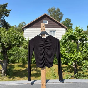 Svart ribbad långärmad topp - Svart långärmad topp från Stradivarius med ribbad struktur och snygg detalj med hål framtill.