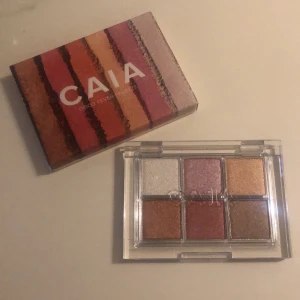 CAIA Disco Fever ögonskuggspalett - Säljer CAIA Disco Fever ögonskuggspalett med sex skimrande nyanser i guld, brons, koppar, silver, lila och brun. Paletten har en genomskinlig plastförpackning och färgerna är perfekta för att skapa glammiga looks.