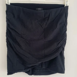 Svart omlottkjol från Lindex - Svart kortkjol från Lindex i omlottmodell med snygga rynkade sidor. 