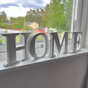 Bokstäver för inredning - Bilderna visar vita dekorativa bokstäver i trä som tillsammans bildar ordet 'HOME'. Inredningsdetaljer för att skapa en mysig känsla i hemmet. Passar perfekt för dig som vill ge ditt rum en personlig touch. Knappt använda. Önskar du veta exakta mått? Tveka inte att höra av dig!
