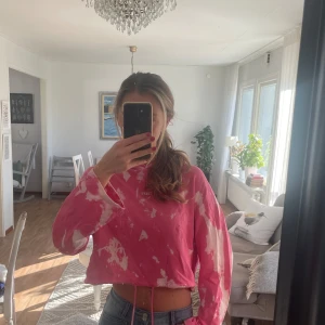Rosa tie-dye hoodie - Säljer en rosa och vit tie-dye hoodie💕. Tröjan är croppad med snörning i midjan och har långa ärmar. Perfekt för dig som gillar en avslappnad och trendig stil. Mjuk luftig bomullskänsla och oversized fit.